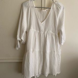 white dress with tassels on sleeves